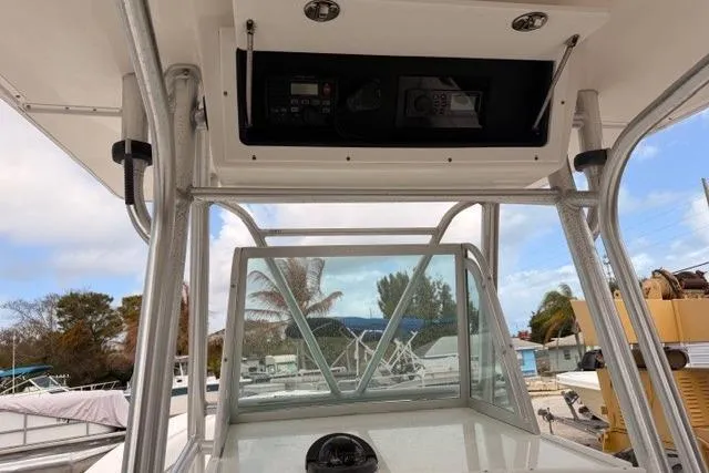Slide: The Image of 2002 Regulator 26 Forward Seating boat console with overhead electronics and clear sky background. - 13