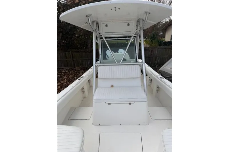 Slide: The Image of 2002 Regulator 26 Forward Seating boat with white cushioned seats and T-top. - 18