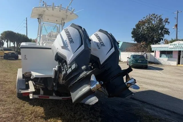 Slide: The Image of 2002 Regulator 26 Forward Seating boat with twin Evinrude engines on a trailer. - 4