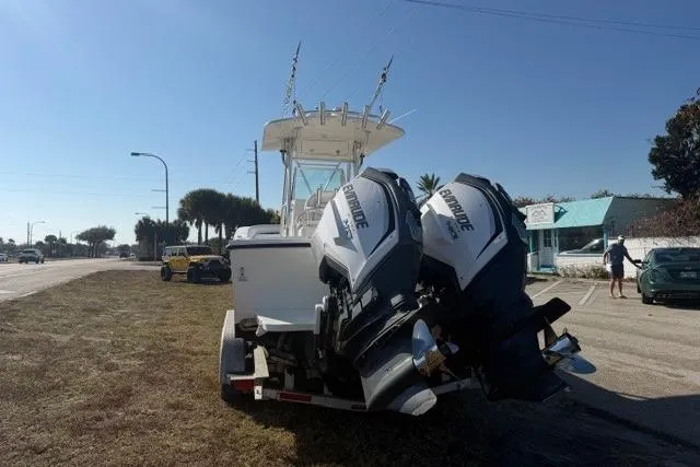 Slide: The Image of 2002 Regulator 26 Forward Seating boat with twin Evinrude engines on a trailer. - 5