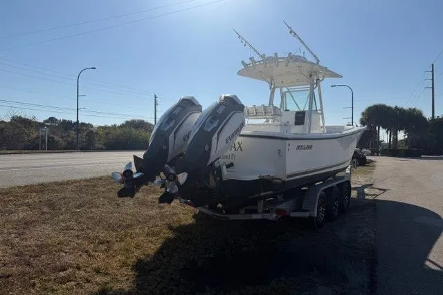 Slide: The Image of 2002 Regulator 26 Forward Seating boat on trailer, dual outboard engines, parked roadside. - 6