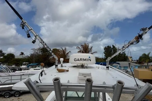 Slide: The Image of 2002 Regulator 26 Forward Seating boat with Garmin equipment, docked under cloudy sky. - 7
