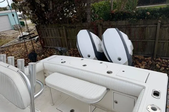 Slide: The Image of 2002 Regulator 26 Forward Seating boat with dual outboard engines, white interior, and rod holders. - 9