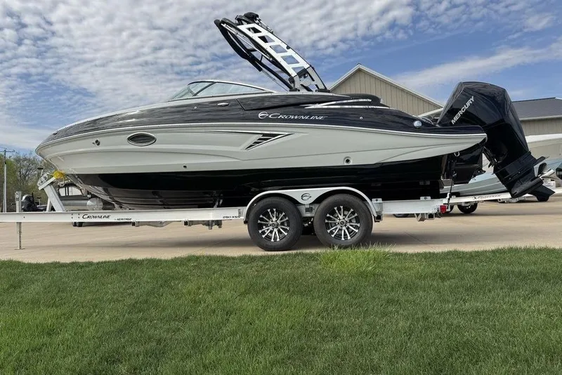 The Image of 2025 Crownline 250 XSS boat on trailer, parked outdoors under a cloudy sky. - 1