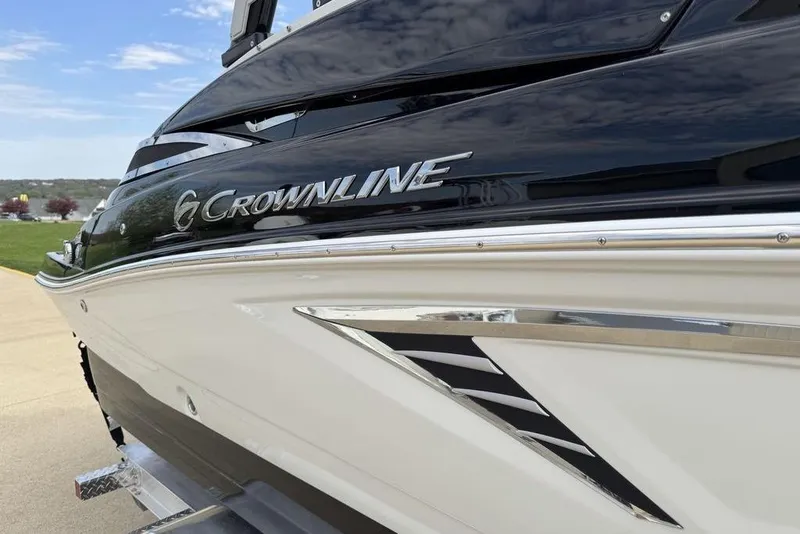 Slide: The Image of 2025 Crownline 250 XSS boat, sleek design with chrome accents, parked outdoors. - 3