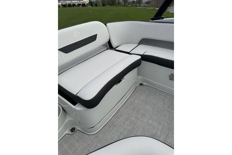 Slide: The Image of 2025 Crownline 250 XSS boat interior with white and black seating, gray flooring. - 7