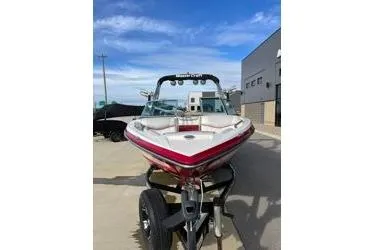 Slide: The Image of 2013 MasterCraft X30 boat on trailer, parked outdoors under blue sky. - 12