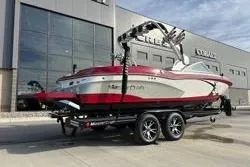 Slide: The Image of 2013 MasterCraft X30 boat on trailer, parked outside a modern building. - 13