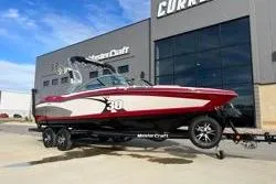 Slide: The Image of 2013 MasterCraft X30 boat in red and white, parked outside dealership. - 7