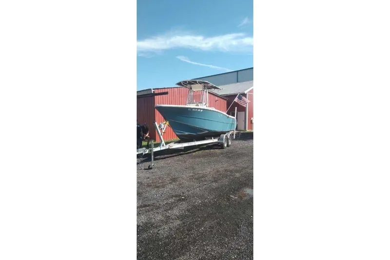 The Image of 2022 Bulls Bay 230 Center Console boat on trailer near red building. - 0