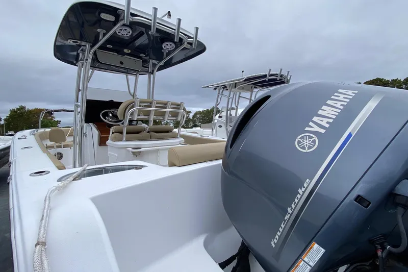 Slide: The Image of 2015 Sportsman Heritage 251 Center Console boat with Yamaha engine, docked under cloudy skies. - 4
