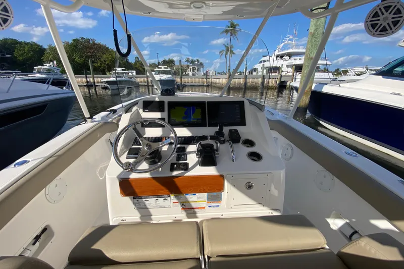 Slide: The Image of Cockpit view of 2015 Pursuit S 280 Sport boat, featuring steering wheel and navigation screens. - 11