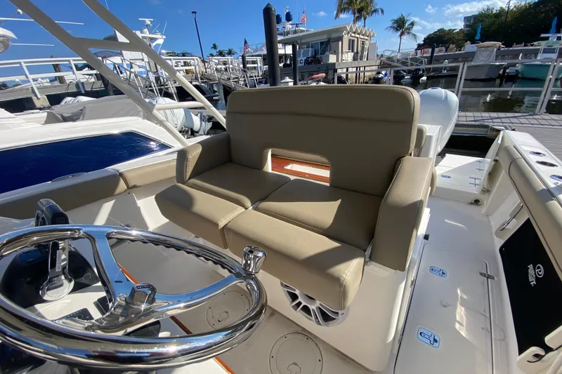 Slide: The Image of 2015 Pursuit S 280 Sport boat interior with steering wheel and seating at marina. - 13