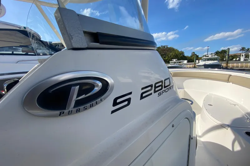 Slide: The Image of 2015 Pursuit S 280 Sport boat, close-up view, docked under clear blue sky. - 22