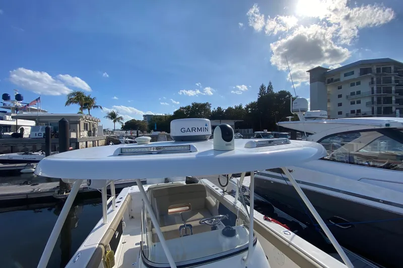 Slide: The Image of 2015 Pursuit S 280 Sport boat docked, featuring Garmin equipment under a sunny sky. - 26