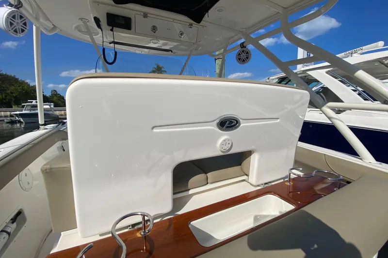 Slide: The Image of 2015 Pursuit S 280 Sport boat interior with seating and cup holders, docked under blue sky. - 9