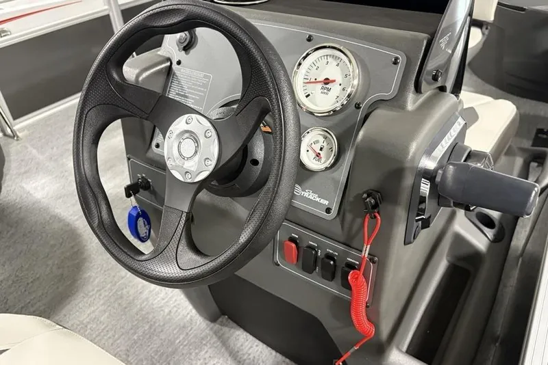 Slide: The Image of 2026 Sun Tracker Bass Buggy 18 DLX steering console with gauges and controls. - 18