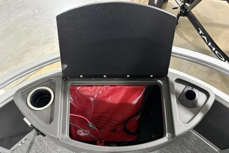 Slide: The Image of 2026 Sun Tracker Bass Buggy 18 DLX storage compartment with cup holders and red bag. - 7