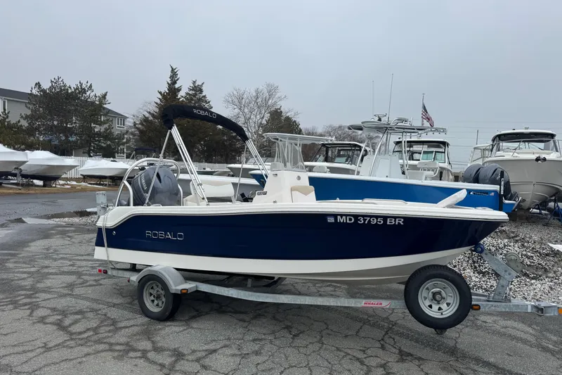 Slide: The Image of 2021 Robalo R160 Center Console boat on trailer in marina setting. - 4