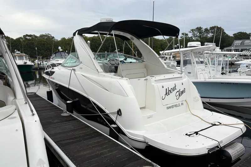 Slide: The Image of 2011 Bayliner 285 Cruiser docked at marina, featuring sleek design and canopy. - 3