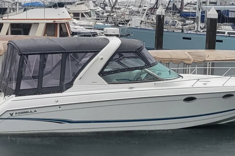 The Image of 2006 Formula 330 Sun Sport boat docked in a marina, featuring a sleek design and covered cockpit. - 0