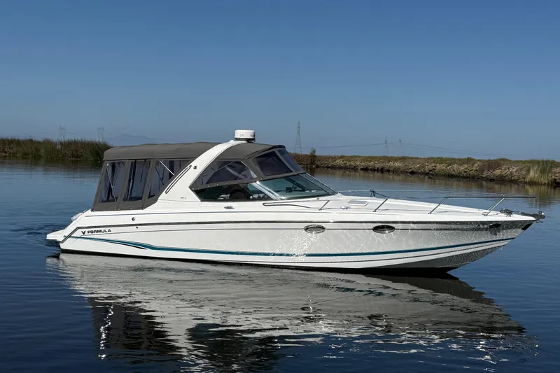 Slide: The Image of 2006 Formula 330 Sun Sport boat cruising on calm water under clear blue sky. - 29
