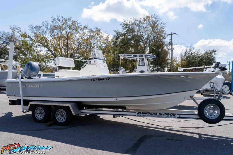 Slide: The Image of 2014 Sea Hunt BX 22 Pro boat on trailer, parked outdoors under a clear sky. - 13