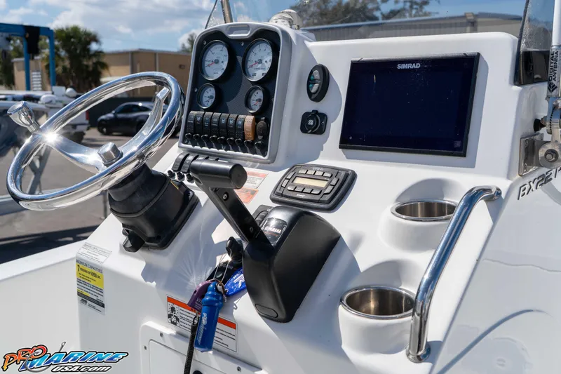 Slide: The Image of 2014 Sea Hunt BX 22 Pro boat dashboard with steering wheel, gauges, and Simrad display. - 18