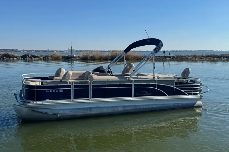 The Image of 2012 Bennington 2275 GFS pontoon boat on calm water with clear blue sky. - 0