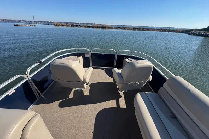 Slide: The Image of 2012 Bennington 2275 GFS pontoon boat interior with seating, on a calm lake. - 11