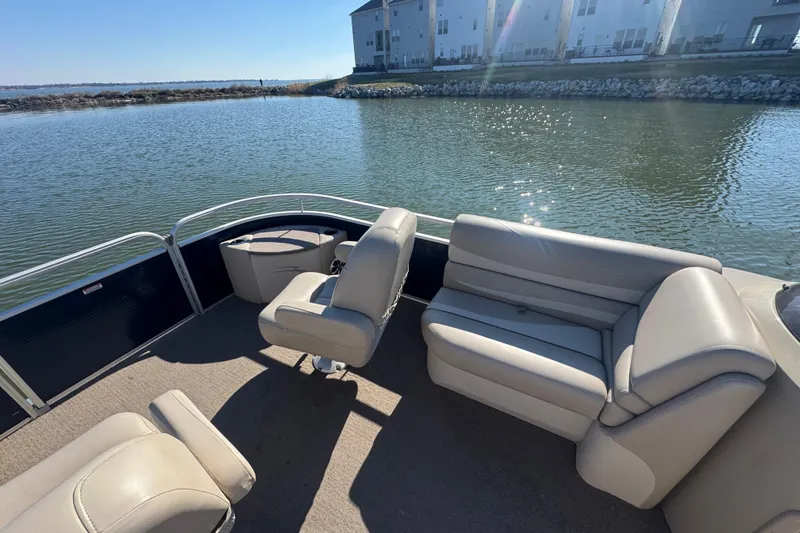 Slide: The Image of 2012 Bennington 2275 GFS pontoon boat interior with beige seating on a sunny day. - 12