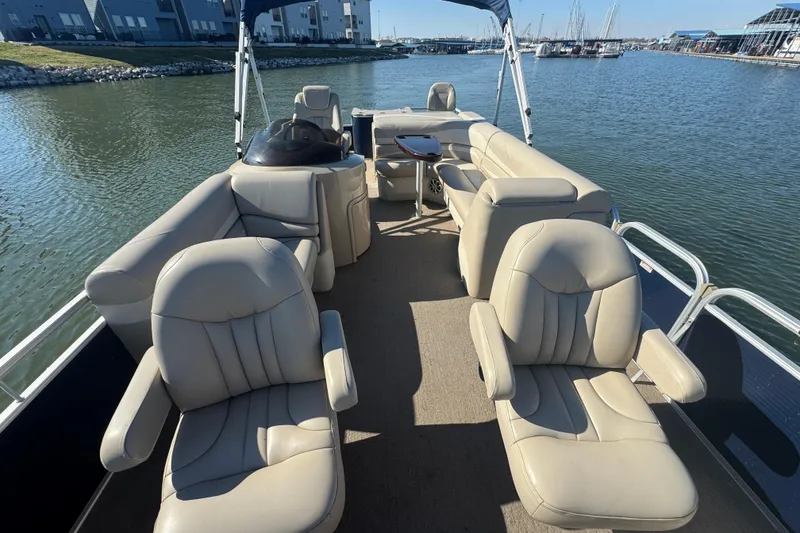 Slide: The Image of 2012 Bennington 2275 GFS pontoon boat with beige seating on a calm lake. - 15