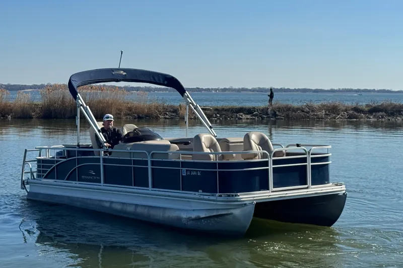 Slide: The Image of 2012 Bennington 2275 GFS pontoon boat on calm water with scenic background. - 2