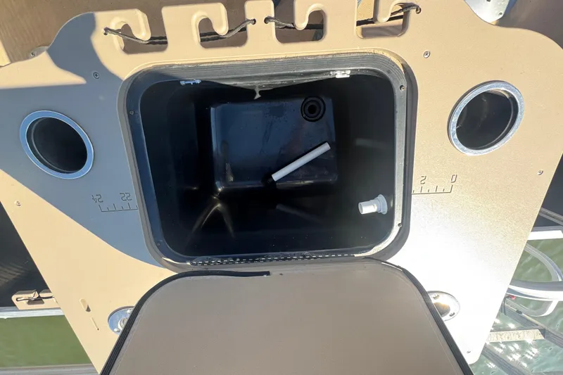 Slide: The Image of Open storage compartment on 2012 Bennington 2275 GFS boat with cup holders and measurements. - 25