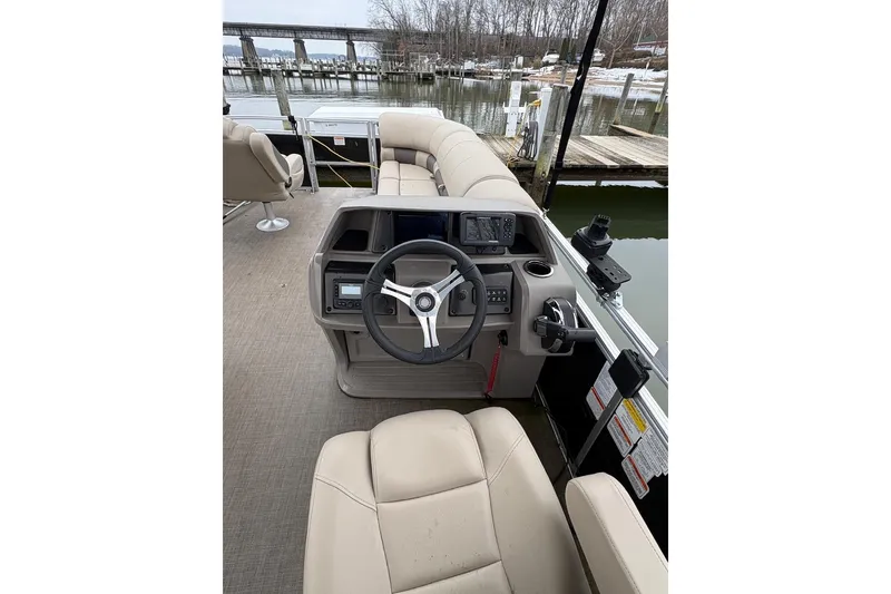 Slide: The Image of 2024 Sun Tracker SportFish 20 DLX pontoon boat interior with steering console and seating. - 3
