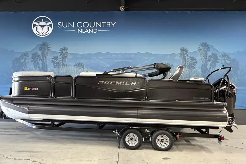 The Image of 2025 Premier 230 Sunsation Angler 2pt pontoon boat on trailer, displayed indoors. - 1