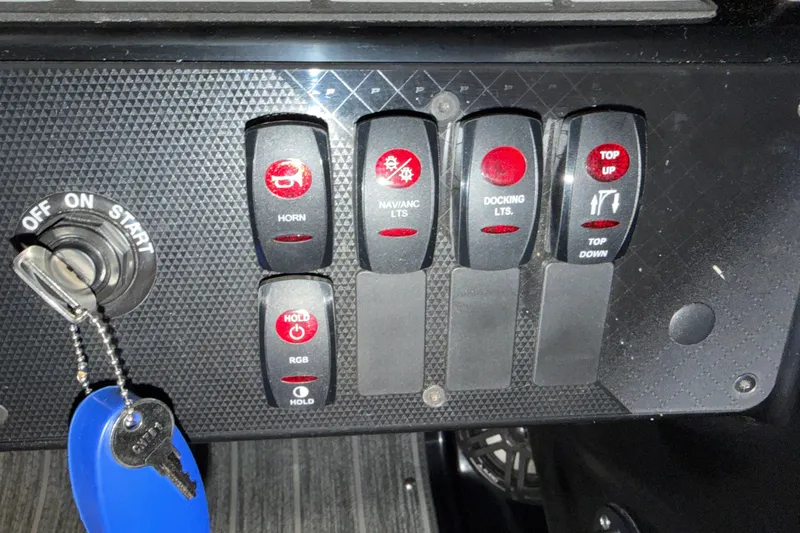 Slide: The Image of Control panel of 2025 Premier 230 Sunsation Angler 2pt with switches and ignition key. - 11