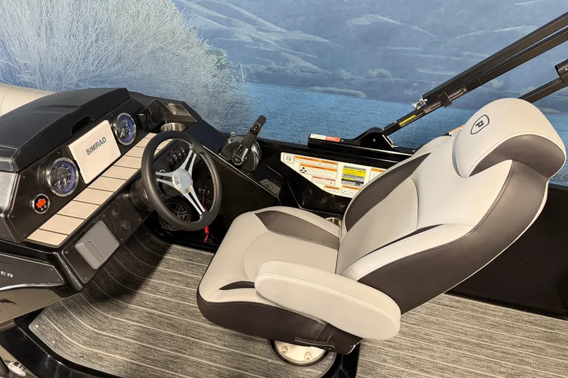 Slide: The Image of 2025 Premier 230 Sunsation Angler 2pt boat interior with steering wheel and captain's chair. - 7