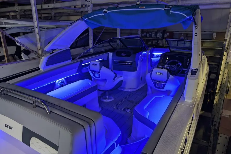 Slide: The Image of 2024 Chaparral 267 SSX boat interior with blue LED lighting and modern seating. - 31