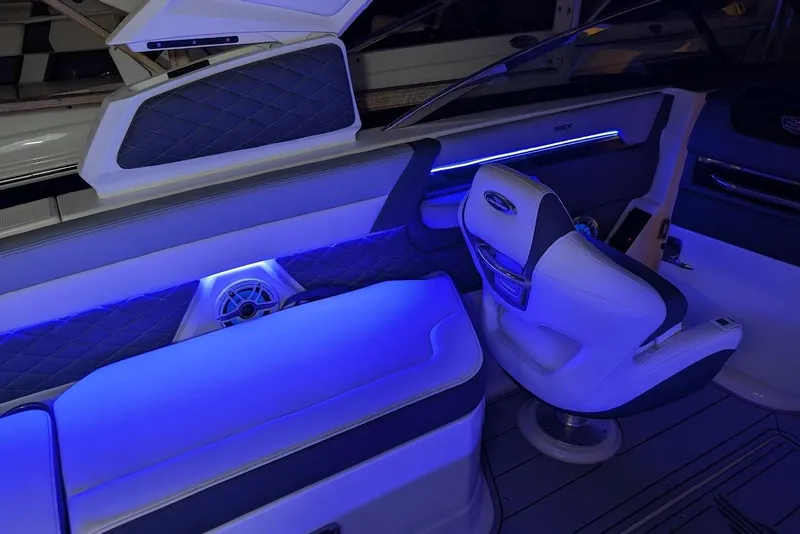 Slide: The Image of 2024 Chaparral 267 SSX boat interior with blue LED lighting and luxurious seating. - 33