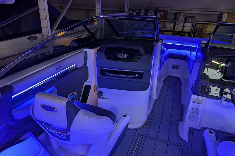 Slide: The Image of 2024 Chaparral 267 SSX boat interior with blue ambient lighting and modern dashboard. - 34