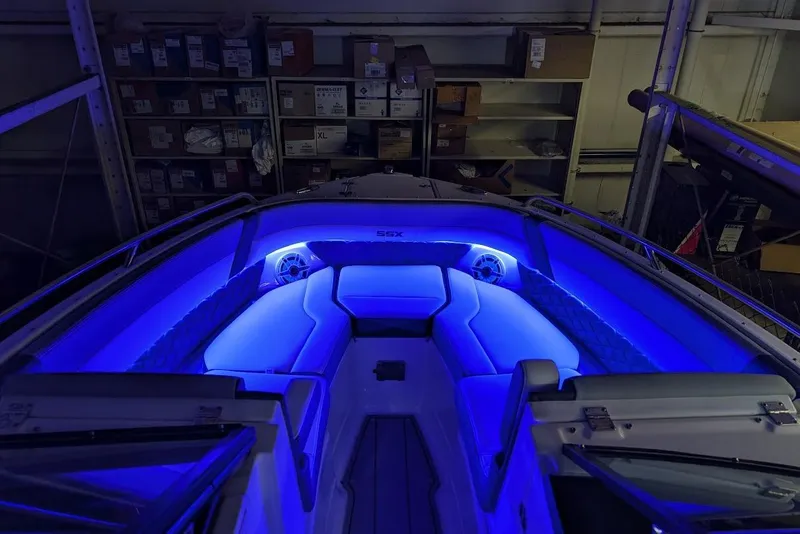 Slide: The Image of 2024 Chaparral 267 SSX boat interior with blue LED lighting in a storage area. - 35