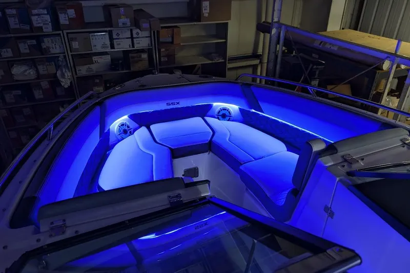 Slide: The Image of 2024 Chaparral 267 SSX boat interior with blue LED lighting in a storage area. - 36