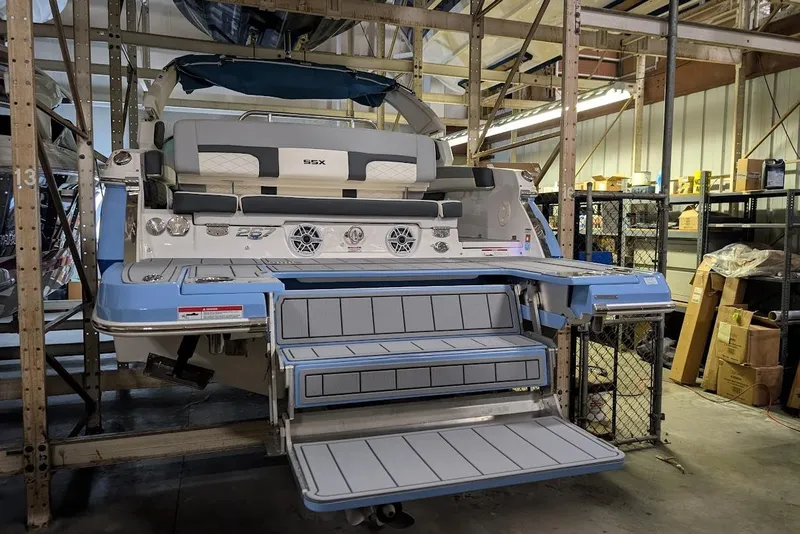 Slide: The Image of 2024 Chaparral 267 SSX boat in storage, showcasing rear seating and swim platform. - 7