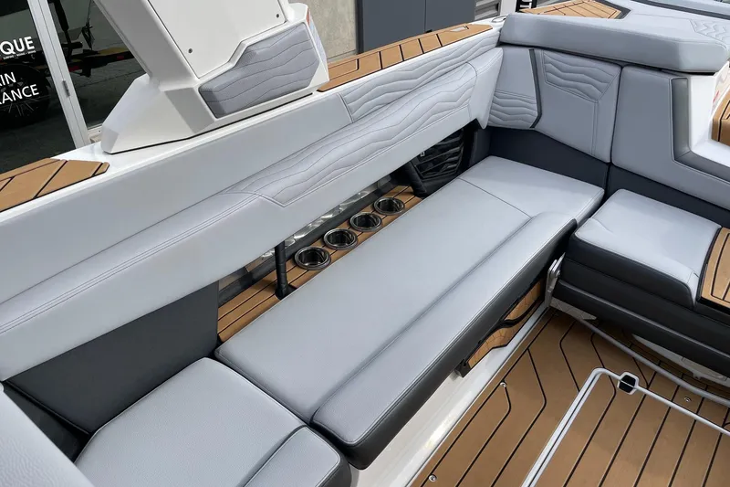 Slide: The Image of 2025 Nautique Super Air Nautique G25 interior with luxurious seating and cup holders. - 7