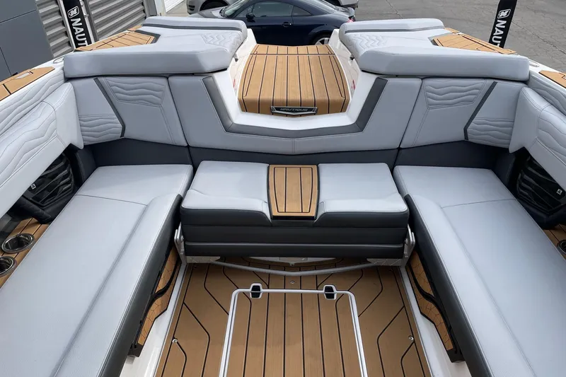 Slide: The Image of 2025 Nautique Super Air Nautique G25 interior with luxurious seating and teak flooring. - 8