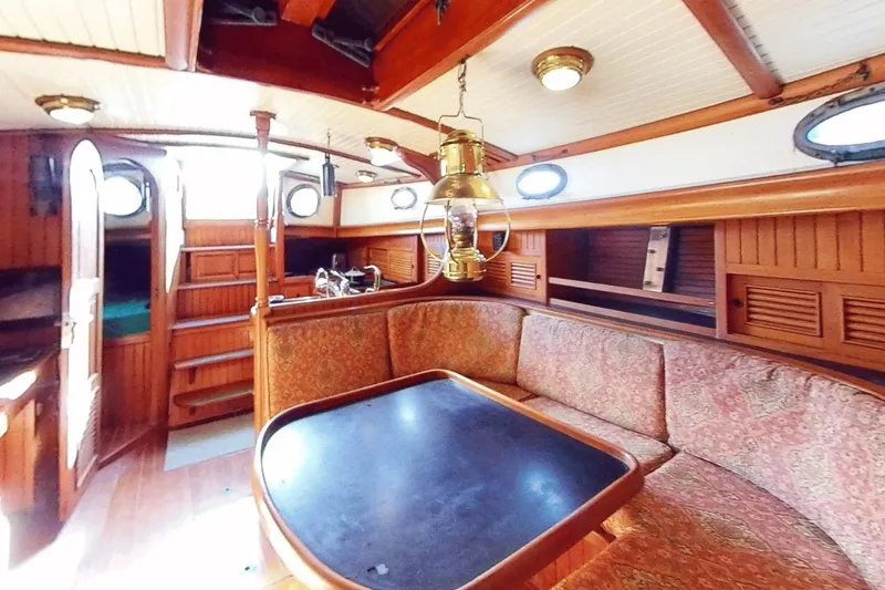 Slide: The Image of Interior of 1985 Hans Christian 38 sailboat with wooden furnishings and cozy seating area. - 10