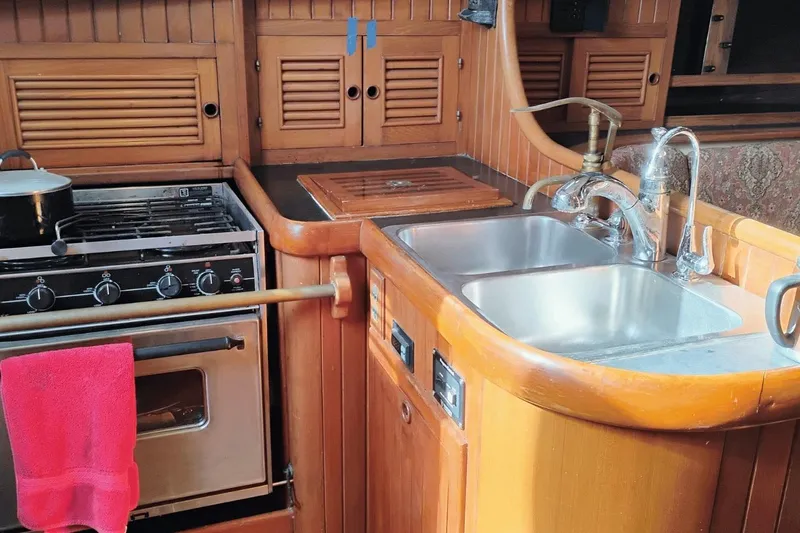 Slide: The Image of Wooden yacht kitchen with stove, double sink, and cabinets in a 1985 Hans Christian 38. - 14