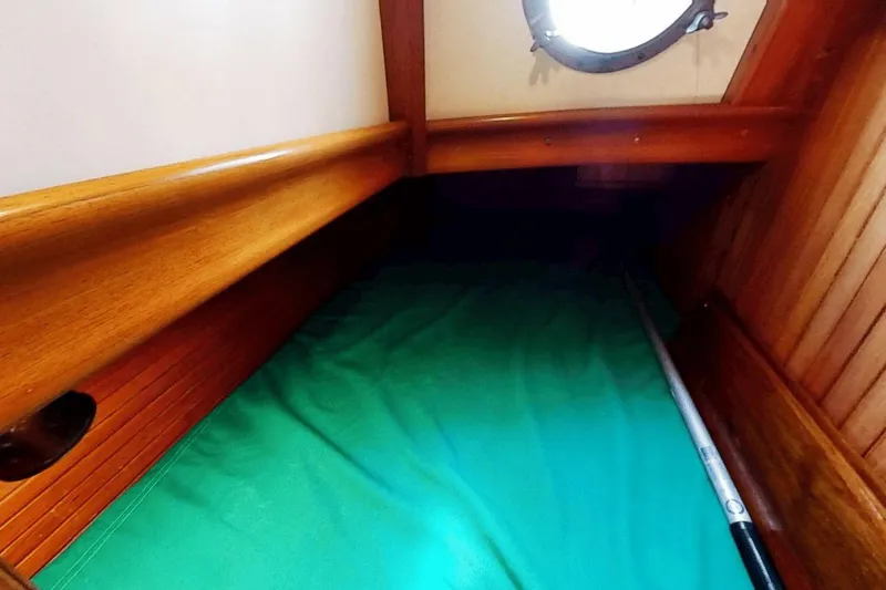 Slide: The Image of Cozy cabin interior of 1985 Hans Christian 38 sailboat with wooden finish and green bedding. - 16