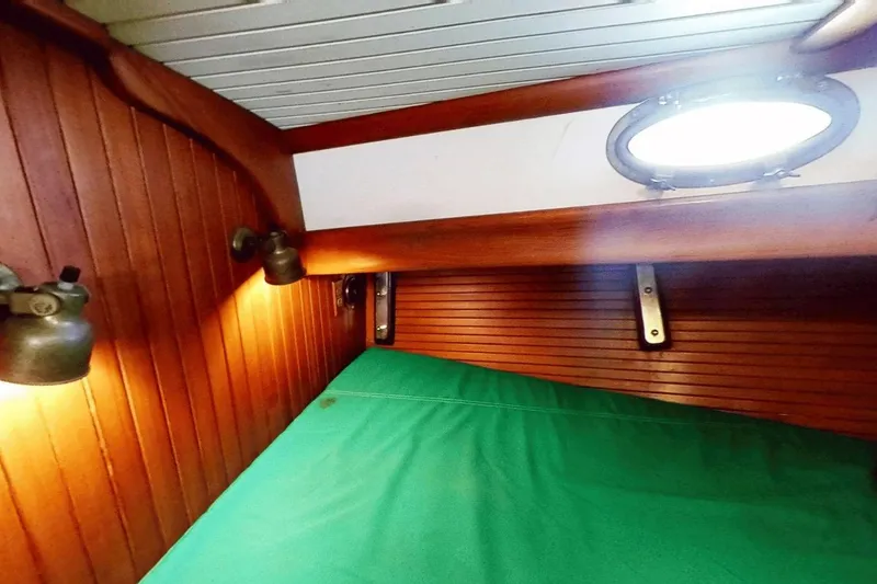 Slide: The Image of Cozy cabin interior of 1985 Hans Christian 38 sailboat with wooden paneling and green bedding. - 18